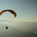 Experience the thrill of paragliding over the stunning Lake Annecy with breathtaking mountain views.